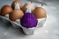 One colored egg among the uncolored on a package container. Trendy Easter glitter colored egg. Easter concept. Not like everyone