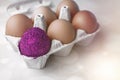 One colored egg among the uncolored on a package container. Trendy Easter glitter colored egg. Easter concept. Not like everyone