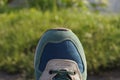 One colored sneaker made of fabric and suede over green grass Royalty Free Stock Photo