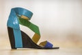 One colorful bright blue, green and yellow leather strap female shoe sandal on high black platform isolated on light copy space