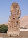 One of the Colossi of Memnon Statues Luxor Egypt taken on a sunny day with blue sky.