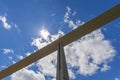 One of concrete pylon of Millau viaduct supports road on background with bright sunny sky with silk clouds. Aveyron