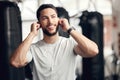 One confident young hispanic man listening to music with earphones to stay motivated while exercising in a gym. Happy Royalty Free Stock Photo