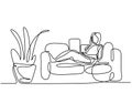 One continuous line drawing of a girl sitting in her sofa. Young attractive and relaxed woman at home smiling happy on sofa couch Royalty Free Stock Photo