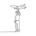 One continuous line drawing of young man launching a toy plane in the field. Happy teenager boy playing airplane into the sky