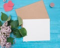 One Craft envelop, white paper, brunch of lilac, hearts, candle on vintage turquoise wooden background