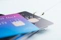 One credit card being stolen by fishing hook from pile of other bank cards