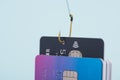 One credit card being stolen by fishing hook from stack of other bank cards, fraud data leak