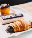 A croissant, a portion of cheesecake and a carrot cake muffin in a pastry shop Royalty Free Stock Photo