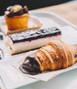 A croissant, a portion of cheesecake and a carrot cake muffin in a pastry shop Royalty Free Stock Photo