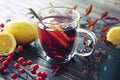 One cup of hot berry and mint tea in autumn leaves decoration, winter autumn mood, citrus red tea