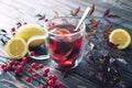 One cup of hot berry tea with lemons  in autumn leaves decoration, winter autumn mood, citrus red tea, autumn concept Royalty Free Stock Photo