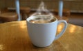 One cup of hot coffee with smoke on round wooden table Royalty Free Stock Photo