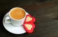 One cup of hot coffee with two heart shaped cookies on dark brown wooden table Royalty Free Stock Photo