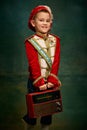 One cute little boy dressed up as medieval little prince and pageboy having fun over dark vintage style background