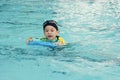 Little asian boy swimming in pool and swim using foampad Royalty Free Stock Photo