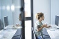 One cute professional woman entrepreneur working on computer and drinking coffee in morning job activity. Bright white office Royalty Free Stock Photo