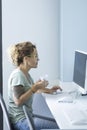 One cute professional woman entrepreneur working on computer and drinking coffee in morning job activity. Bright white office Royalty Free Stock Photo