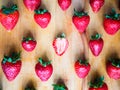 One cutted strawberry in an srranged pattern of strawberries on