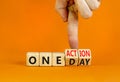 One day and action symbol. Concept words One day and One action on wooden cubes. Businessman hand. Beautiful orange table orange Royalty Free Stock Photo