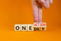 One day and action symbol. Concept words One day and One action on wooden cubes. Businessman hand. Beautiful orange table orange Royalty Free Stock Photo