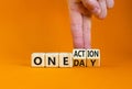 One day and action symbol. Concept words One day and One action on wooden cubes. Businessman hand. Beautiful orange table orange Royalty Free Stock Photo