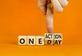 One day and action symbol. Concept words One day and One action on wooden cubes. Businessman hand. Beautiful orange table orange Royalty Free Stock Photo
