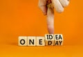 One day and idea symbol. Concept words One day and One idea on wooden cubes. Businessman hand. Beautiful orange table orange Royalty Free Stock Photo