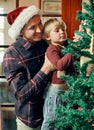 One day youll be as tall as this tree. an adorable little boy decorating the Christmas tree with his father at home. Royalty Free Stock Photo