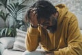 One desperate frustrated man alone at home holding his head on hand looking down. Stress and bad mental health condition concept. Royalty Free Stock Photo