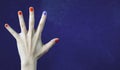 One different nail color in finger in caucasian hand. Red and blue painted fingernails. Royalty Free Stock Photo