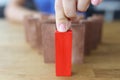 One different red cube block among wooden blocks closeup Royalty Free Stock Photo