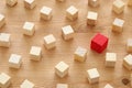 One different red cube block among wooden blocks. Individuality, leadership and uniqueness concept. Royalty Free Stock Photo