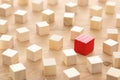 One different red cube block among wooden blocks. Individuality, leadership and uniqueness concept. Royalty Free Stock Photo