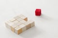 One different red cube block among wooden blocks. Individuality, leadership and uniqueness concept. Royalty Free Stock Photo