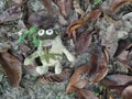 One dirty thrown away frog soft toy laying on the bushy field