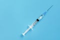 One disposable syringe on a blue background. Space for text