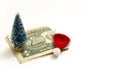 The concept of New Year`s spending. One dollar, a Christmas tree souvenir and a red Santa Claus hat on a white background. Shallo Royalty Free Stock Photo