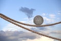 One dollar coin balancing on rope Royalty Free Stock Photo