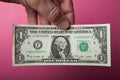 One dollar in hand on a pink background Royalty Free Stock Photo