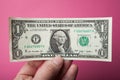 One dollar in hand on a pink background Royalty Free Stock Photo