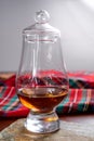 One dram of scotch whisky with red scottish tartan on background