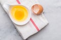 One egg yolk in white bowl and broken egg shells Royalty Free Stock Photo