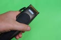 Electric black clipper in hand on a green background Royalty Free Stock Photo