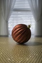 One Elegant Red Ball on Gold Mat in front of window Royalty Free Stock Photo