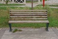 One empty brown wooden bench stands in green grass Royalty Free Stock Photo