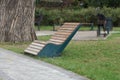 One empty brown wooden bench stands in green grass Royalty Free Stock Photo