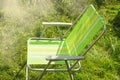 One empty folding garden chair for relaxing stands on the green grass on the lawn on a Sunny summer day, a copy of the space Royalty Free Stock Photo