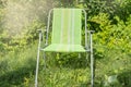 One empty folding garden chair for relaxing stands on the green grass on the lawn on a Sunny summer day, a copy of the space Royalty Free Stock Photo