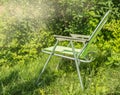 One empty folding garden chair for relaxing stands on the green grass on the lawn on a Sunny summer day, a copy of the space Royalty Free Stock Photo